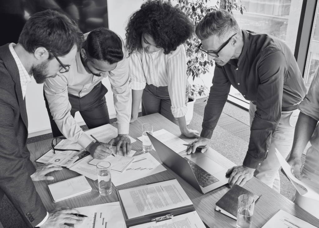 A team collaborating around a whiteboard, symbolising the importance of weekly planning check-ins.