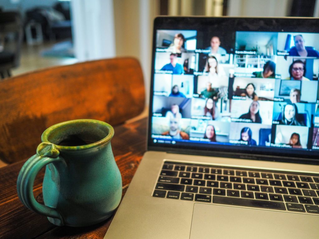 Laptop screen showing a virtual meeting with diverse participants, symbolizing remote team collaboration and communication in virtual settings.